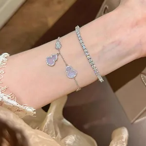 Detail view of elegant silver gourd charm bracelet and sparkling tennis bracelet set