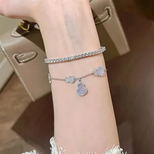 Detailed view of fashionable zircon gourd pendant and tennis bracelets on a female wrist