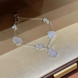 Close-up detail of silver zircon gourd pendant bracelet with white shell inlay on box