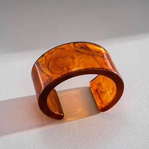 Macro detail of high-end vintage marbled resin cuff bracelet with rich amber tones