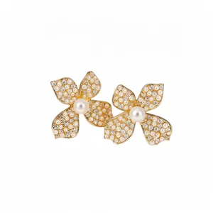 Elegant gold-tone flower stud earrings with pearls and sparkling cubic zirconia stones.