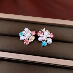 Detailed macro view of colorful zircon floral cluster earrings with elegant pearls