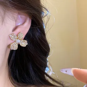 Close-up detail of vintage flower stud earring with zircon and pearl center.