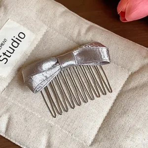 Detailed view of an elegant silver satin bow hair comb featuring a premium metal insert design
