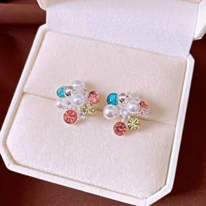 Close-up of elegant flower cluster stud earrings with colorful zircon and pearls in a box.