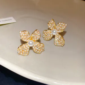 Detailed macro shot of elegant vintage flower stud earrings with zircons and pearls