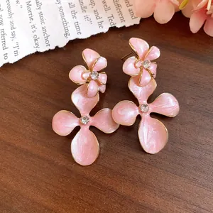 Exquisite detail view of pink enamel flower earrings with sparkling crystal centers.