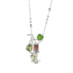 Detalle de un collar de cóctel de plata con gemas verdes en forma de corazón y lágrima