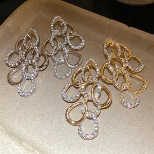 Elegant gold and silver twisted teardrop pendant earrings with sparkling pave rhinestones