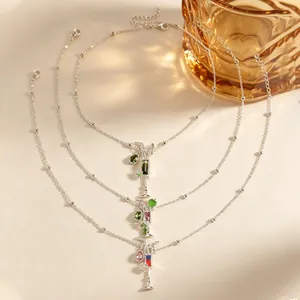 Vista detallada de tres collares con forma de cóctel, piedras de colores y cadenas finas