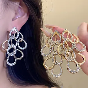 Detailed shot of sparkling rhinestone teardrop earrings in gold and silver colors