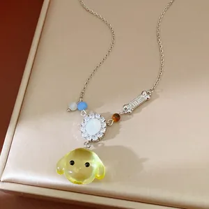 Dettaglio della collana con cane in resina gialla e osso con zirconi brillanti