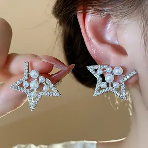 Detail shot of elegant star-shaped zircon stud earrings with white pearls on a model