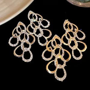 Exquisite macro view of rhinestone drop earrings with twisted water drop design in silver and gold