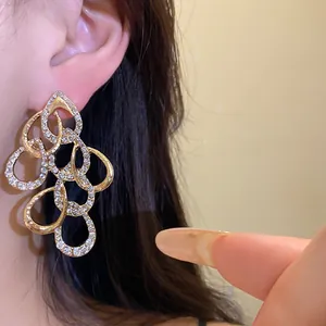 Close-up of elegant gold-toned waterdrop earrings with sparkling rhinestone crystals