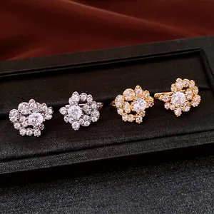 Sparkling zircon cluster stud earrings in elegant gold and silver finishes on display