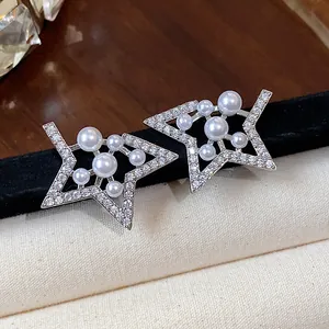 Macro view of elegant star shaped stud earrings featuring sparkling zircon and white pearls