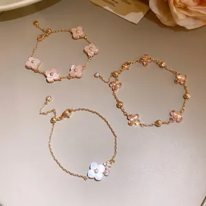 Close-up of cherry blossom pink shell and zircon flower bracelets in rose gold