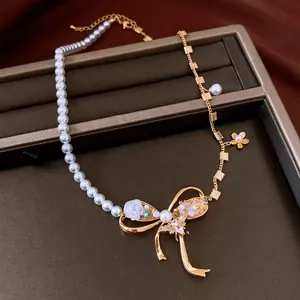 Vintage bow necklace detail with white pearls and sparkling zircon flower accents.
