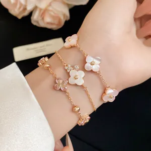 Close-up of pink and white shell flower bracelets with zircons on a wrist