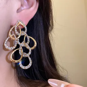Close-up detail of luxurious gold-toned rhinestone waterdrop earrings on model