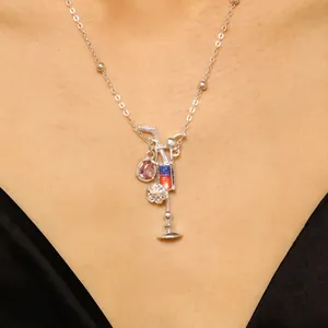 Primer plano detallado de un collar con colgante de copa de cóctel de colores en un modelo