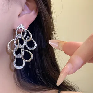 Detail view of luxury rhinestone pavé interlocking teardrop drop earrings for women.