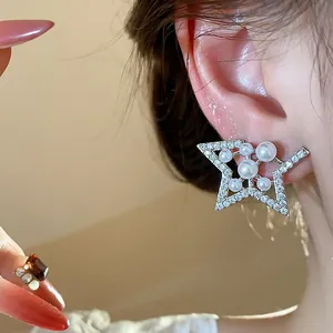 Macro view of silver star earrings featuring white pearls and sparkling cubic zirconia