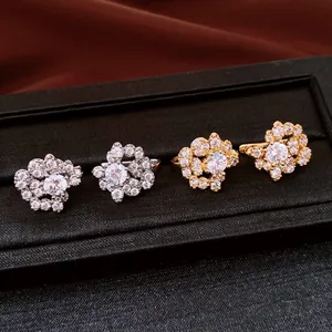 Detailed view of silver and gold zircon flower earrings in a black display box