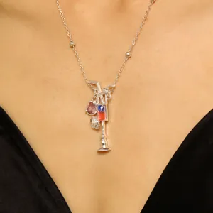 Vista detallada de un collar con colgante de cóctel de plata con piedras rosas y azules