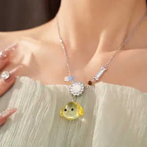 Dettaglio di una collana con ciondolo a cane in resina con zirconi e osso decorativo.