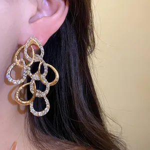 Detail view of twisted gold waterdrop earrings with sparkly rhinestone accents