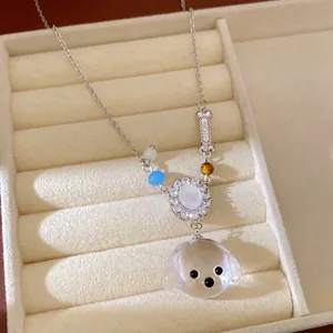 Vista dettagliata di una collana con ciondolo a forma di cucciolo e osso con zirconi brillanti