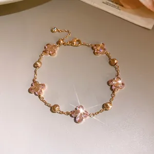 Detailed view of an elegant pink zircon cherry blossom flower bracelet with gold beads