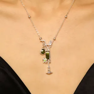Detalle de primer plano del collar con colgante de copa de cóctel y gema verde