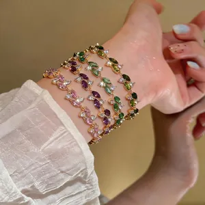 Elegante set di bracciali in zirconia colorata placcata oro indossati al polso