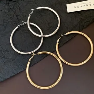 Large minimalist hoop earrings in polished gold and silver finishes