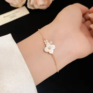 Macro view of mother-of-pearl flower bracelet with rose gold chain and zircons