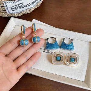 Macro detail of 18k gold plated vintage earrings featuring turquoise and zircon stones