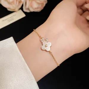 Detail shot of a rose gold flower bracelet with mother-of-pearl and zirconia on a wrist