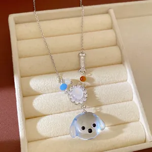 Primo piano di una collana con carino cagnolino in resina e ciondolo con zirconi.