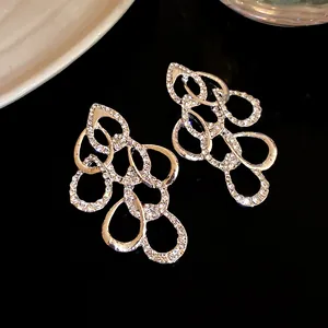 Close-up of elegant silver earrings with twisted teardrop design and rhinestones