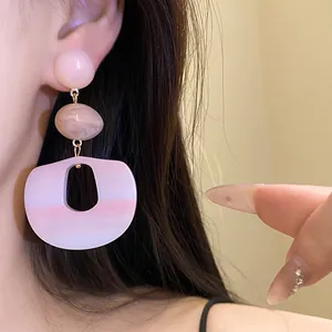Detail shot showing the elegant pink gradient acrylic pendant earrings on the ear