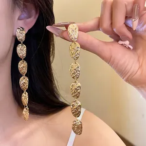 Pendientes colgantes ovalados de metal martillado dorado para un look chic.