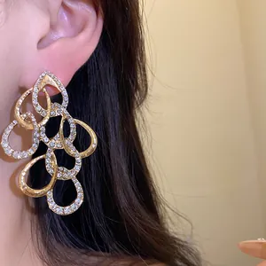 Detailed view of luxury gold-plated twisted teardrop earrings with pavé rhinestones