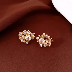 Macro view of sparkling zircon gold-plated ear clips with flower-like pattern.