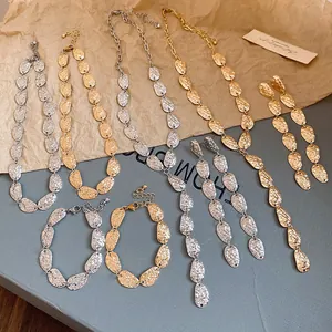 Vista detallada de conjuntos de joyas con collares y pulseras de eslabones ovalados de metal.