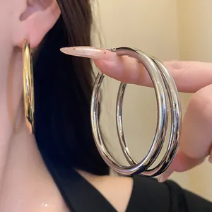 Macro view of polished thick gold and silver metal hoop earrings with minimalist retro design