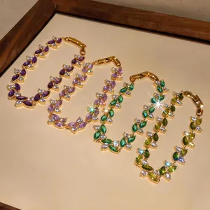 Dettaglio di bracciali colorati in zircone placcati oro in tonalità viola e verde