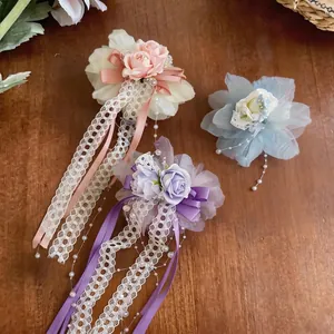 Elegante lila Spitzenblumen-Haarspangen mit feinen Bändern und dekorativen Perlenquasten